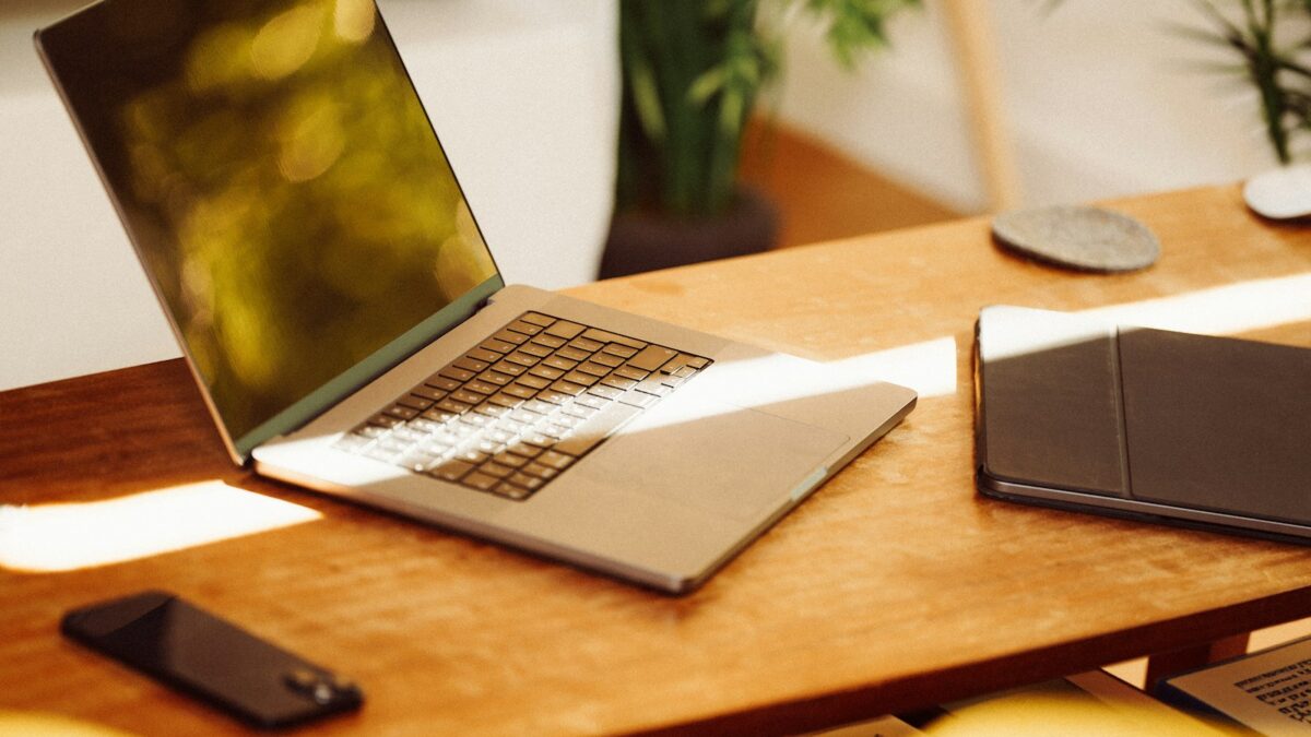 A laptop computer sitting on top of a wooden desk