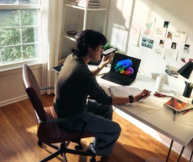 Person working at a desk with a laptop and books.